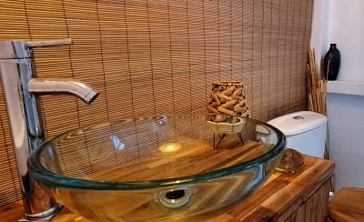 vasque transparente verre sur table bois et wc devant store bambou hébergement coco carib, Deshaies Guadeloupe vasque transparente verre sur table bois et wc devant store bambou hébergement coco carib, Deshaies Guadeloupe