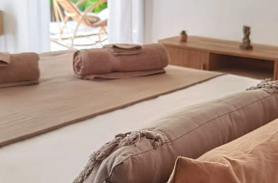 Lit lit marron beige serviette bain enroulées vue terrasse